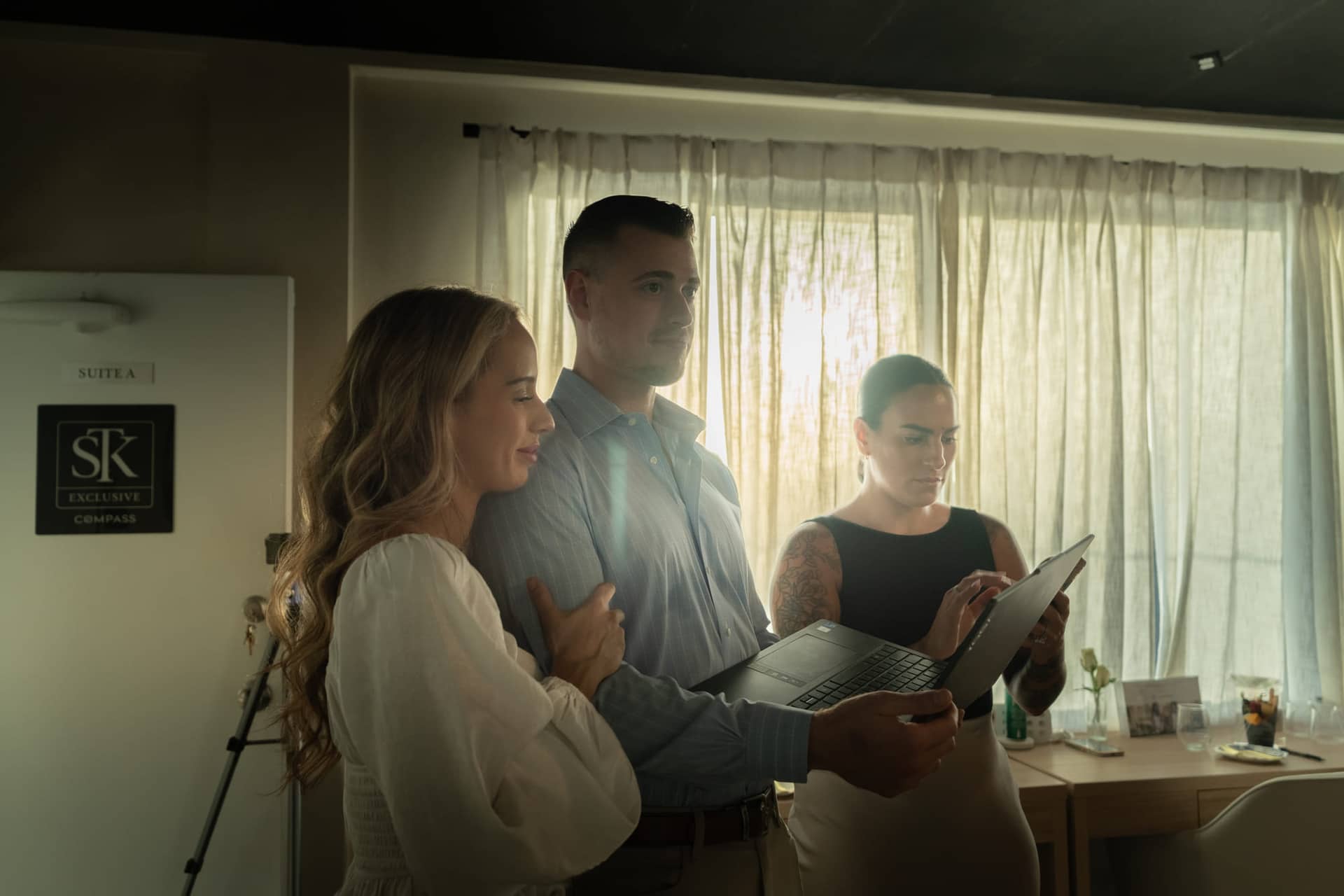Christopher Molina walking two advisors through numbers on a laptop in window light